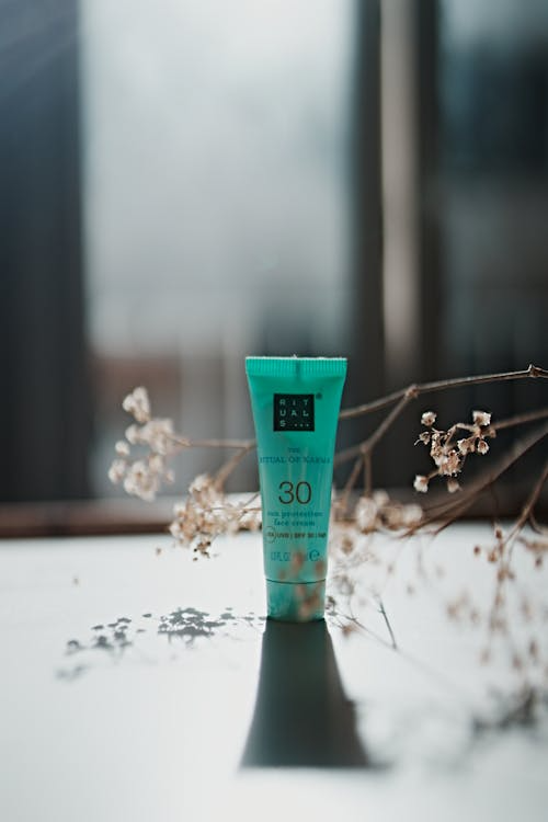 Applying sunscreen on face in morning skincare routine for glowing skin .